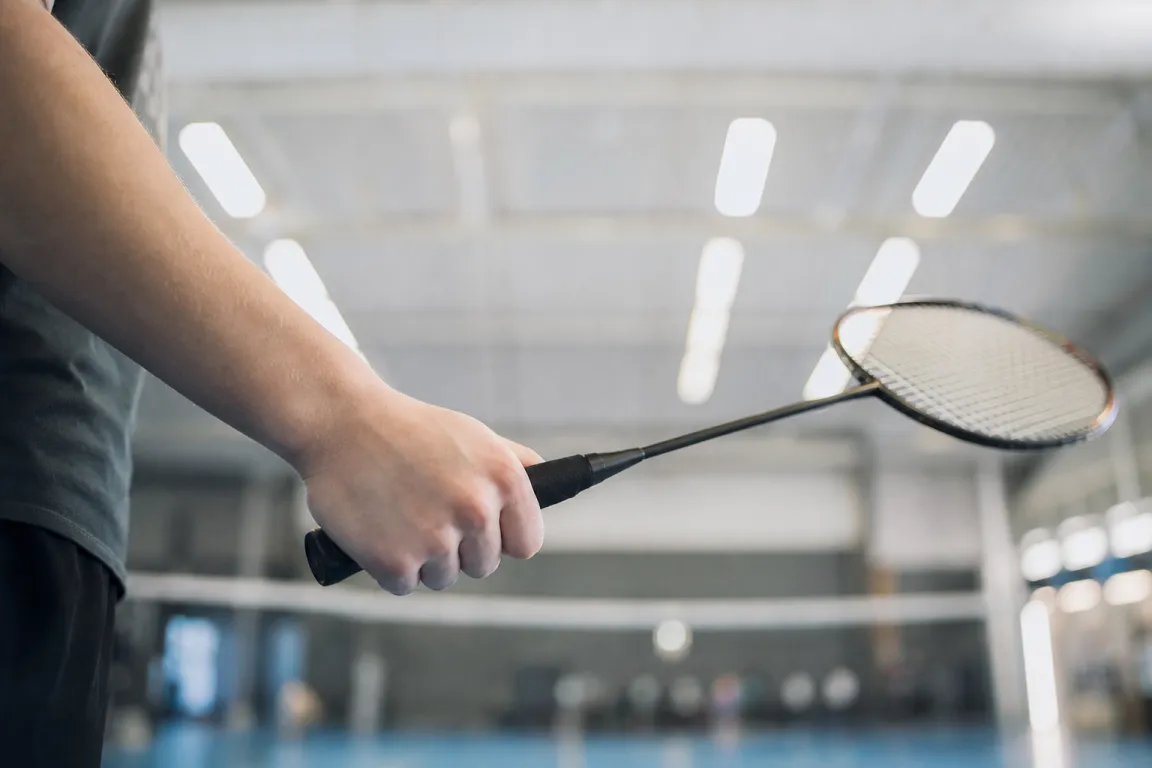 Närbild på en hand som greppar ett badmintonracketskaft