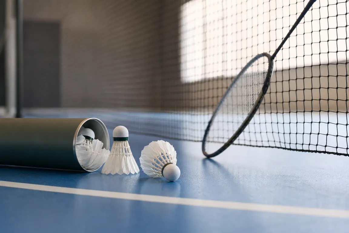 Öppen tub med badmintonbollar på kanten av en badmintonbana
