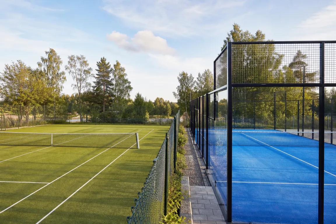 Tennisbana och padelbana sedda sida vid sida i nordiskt dagsljus